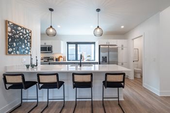 a kitchen with a large island with four chairs at Matilda 235 Townhomes, Iowa